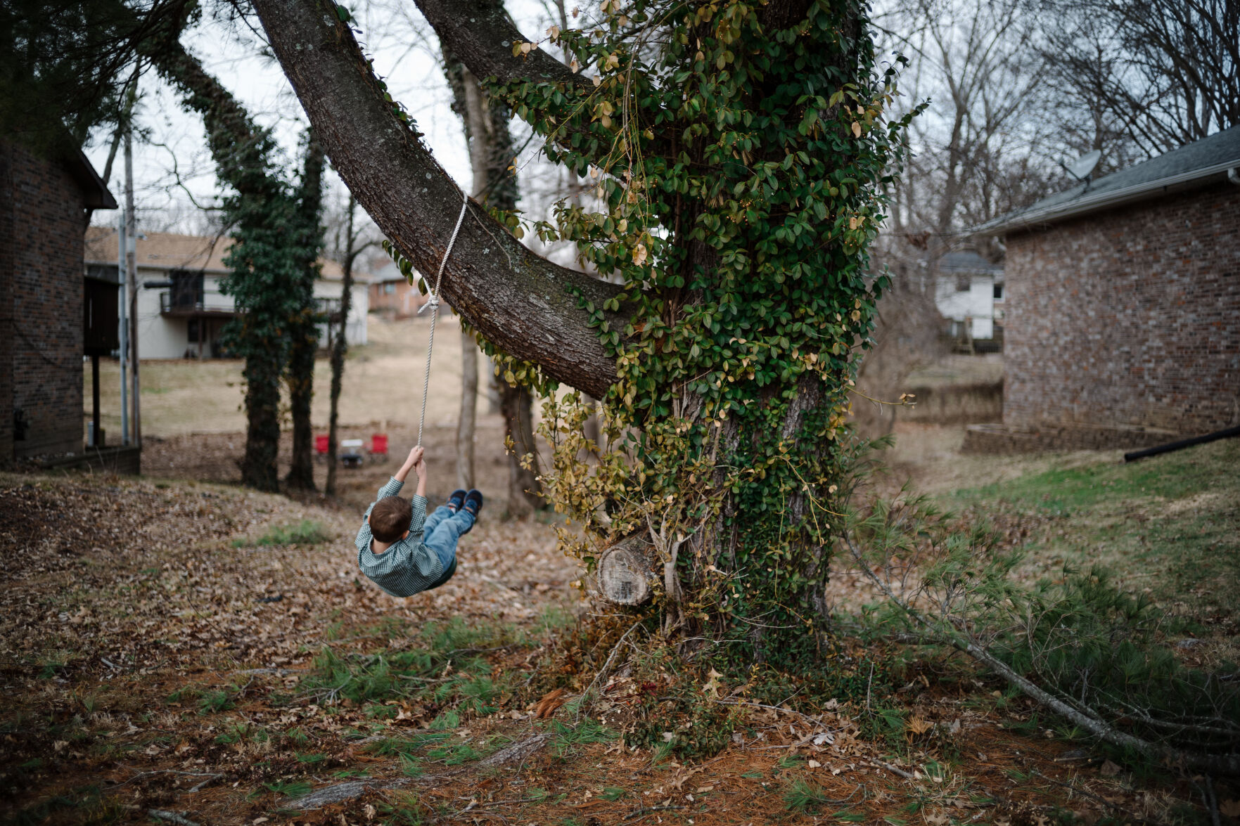 Jackson Busch, 6, plays on a tree swing beside his home Wednesday